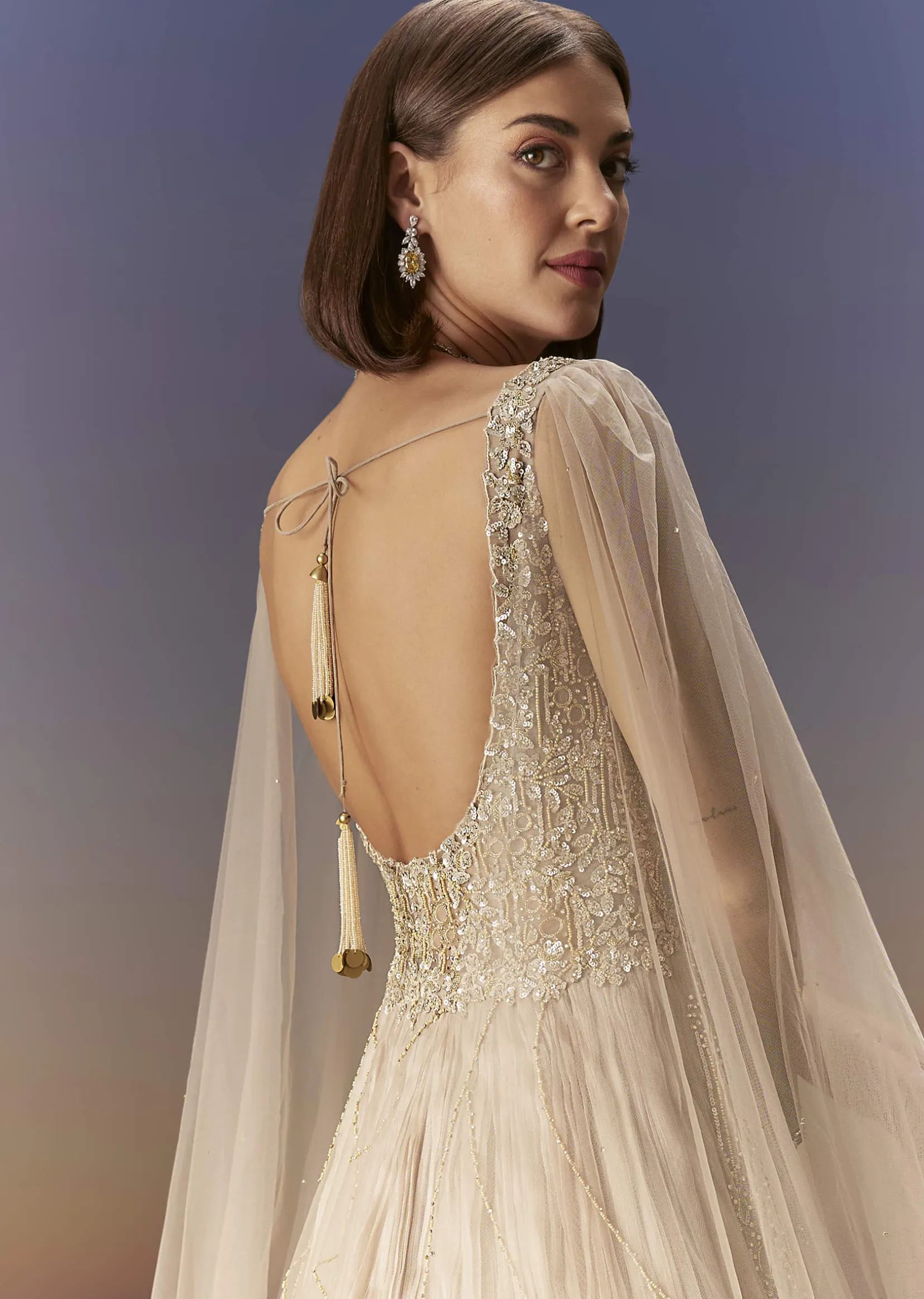 Gold Gown With Pleated Panels And Dramatic Cape