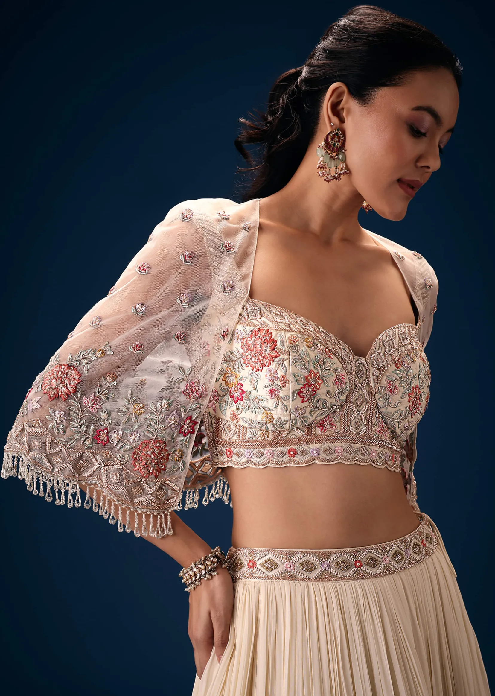 Off White Tiered Lehenga With Embroidered Corset Blouse And Embroidered Cape