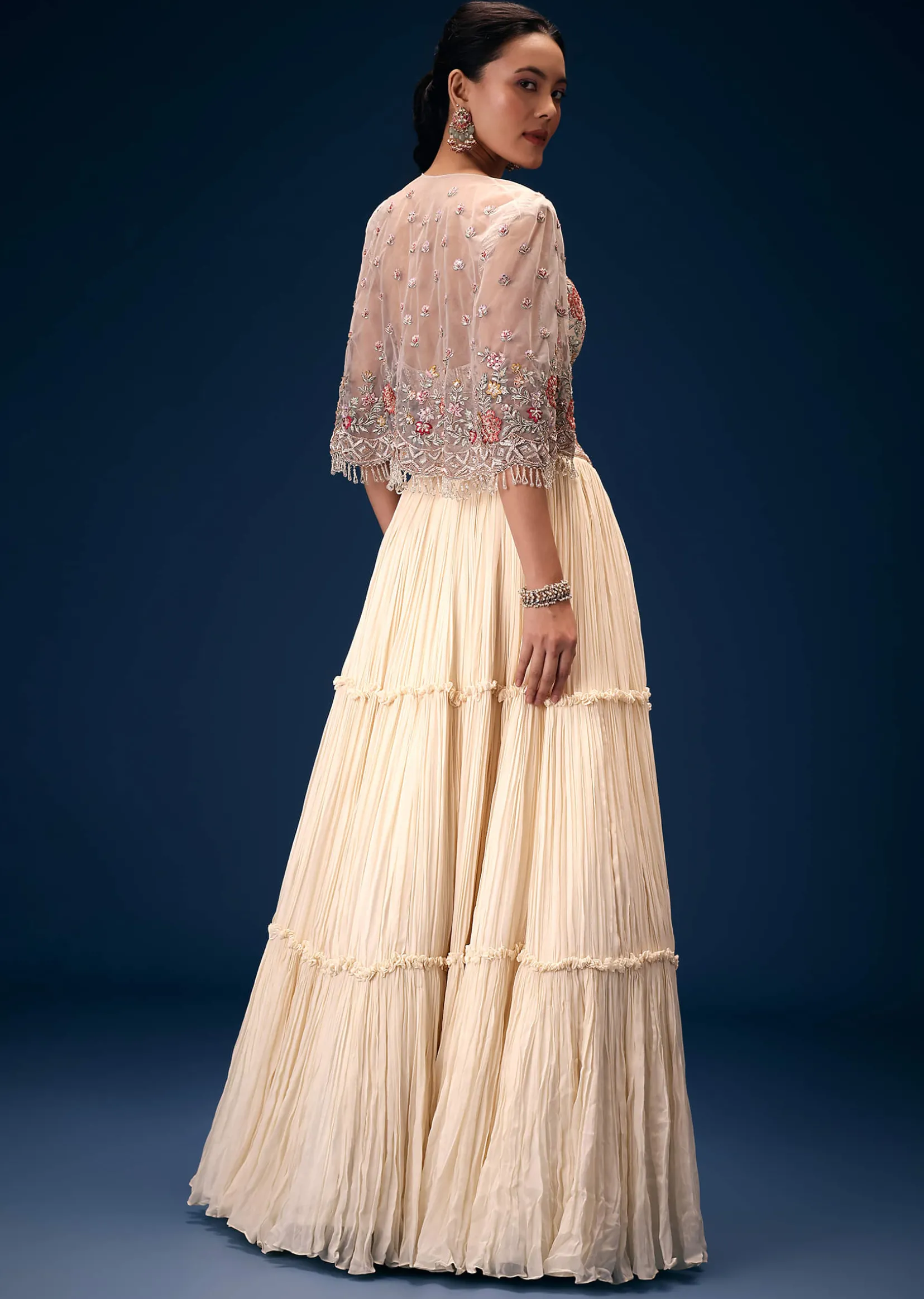 Off White Tiered Lehenga With Embroidered Corset Blouse And Embroidered Cape