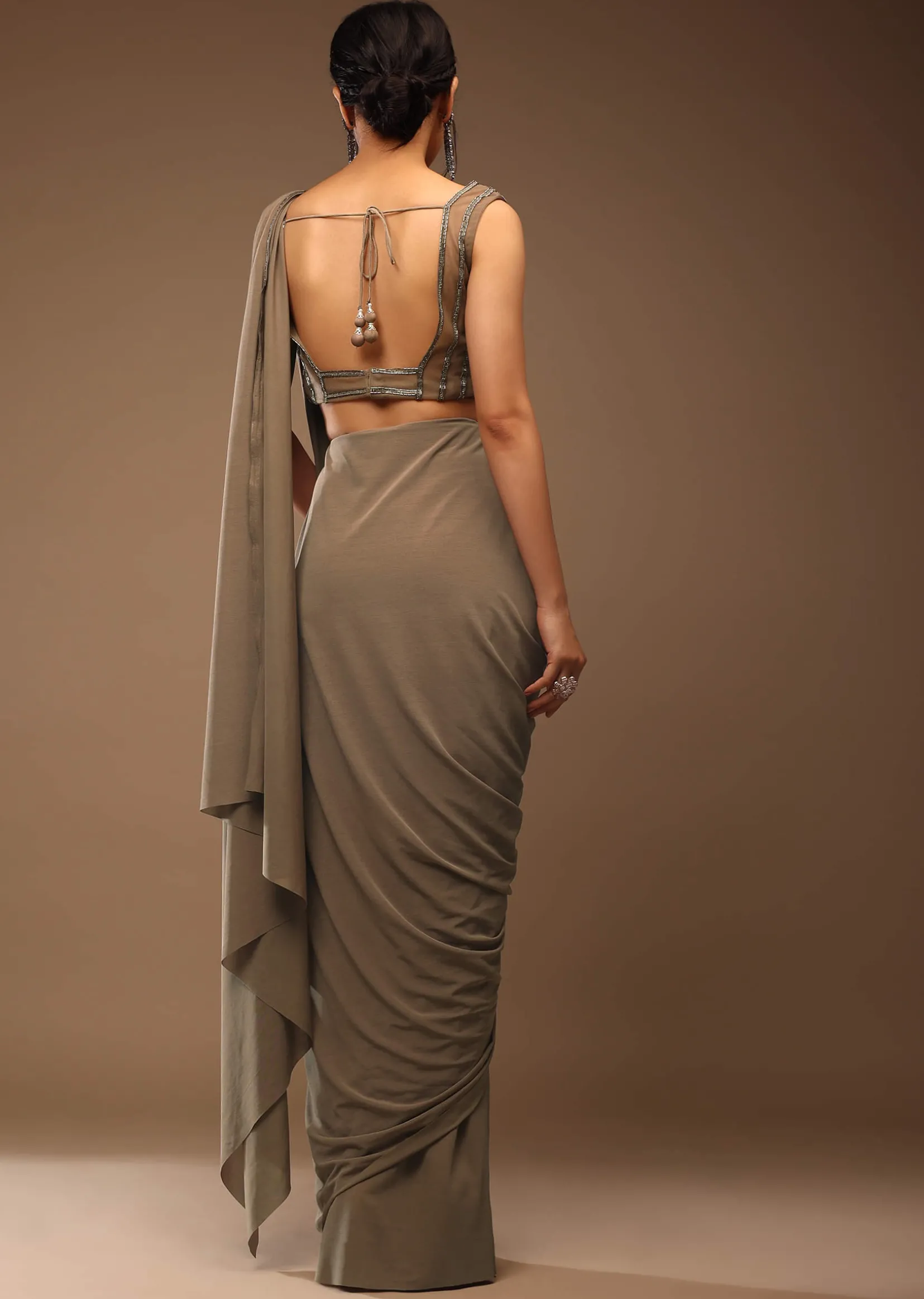 Taupe Grey Ready To Wear Saree With A Crop Top In Foil Applique Embellishment Sleeveless With A Tie-Up Tassel Dori At The Back.